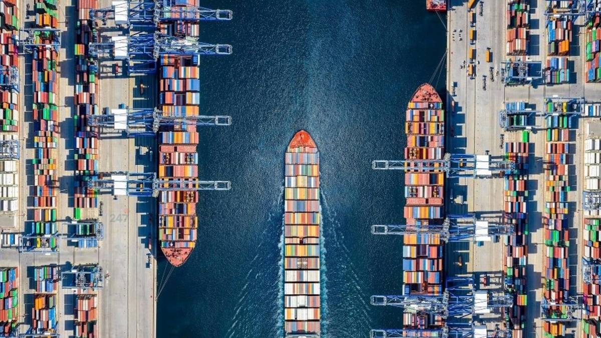 Cảng container với nhiều tàu chở hàng neo đậu, phản ánh tình trạng dư cung tàu khiến giá cước vận tải biển chững lại